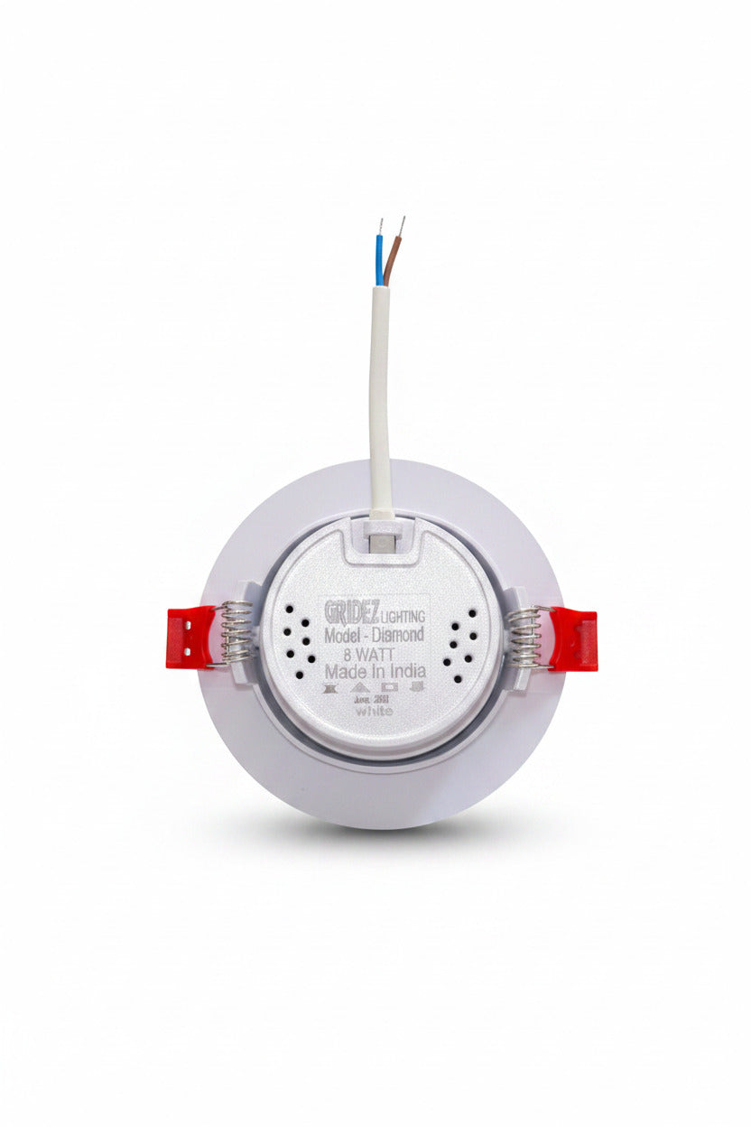 DEEP LIGHT COB 5-watt recessed LED downlight from the brand ODE Lighting, shown from the back with its white circular trim, silver metal core, red spring clips, and exposed blue/white wires, resting on a dark speckled granite countertop.